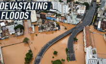 Drone footage shows an urban road submerged under water. Caption reads: "Devastating floods"