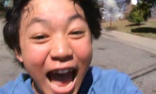 A still from 'Dìdi' showing a young Asian boy running toward the camera and laughing.