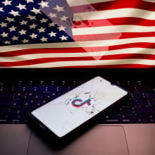 A photo of the U.S. flag and a broken phone screen with the TikTok logo on it 