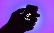 A TikTok logo displayed on a smartphone with a purple background.