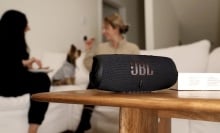 two women sitting on couch with jbl charge 5 speaker
