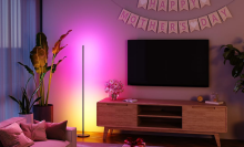 A Govee floor lamp radiating color onto a living room wall
