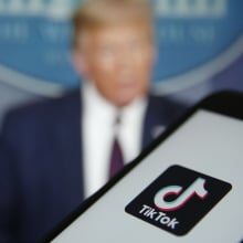 The TikTok logo is displayed in the app store in this arranged photograph in view of a video feed of U.S. President Donald Trump in London, U.K., on Monday, Aug. 3, 2020. TikTok has become a flash point among rising U.S.-China tensions in recent months as U.S. politicians raised concerns that parent company ByteDance Ltd. could be compelled to hand over American users data to Beijing or use the app to influence the 165 million Americans, and more than 2 billion users globally, who have downloaded it.