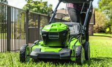 A person pushing a Greenworks mower