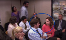 The cast of "The Office" sitting in a conference room. A man and a woman are circled.