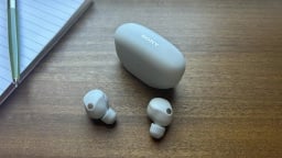 sony earbuds and case next to pad of paper and pen