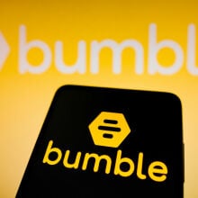 Bumble logo seen displayed on a smartphone and in the background.