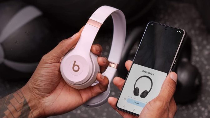 person holding Beats Solo 4 headphones and phone