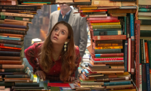Máiréad Tyers looks through a hole in a wall of books in the TV series "Extraordinary."
