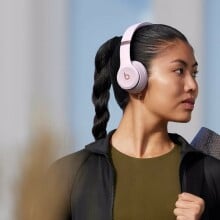 A woman wears a pair of Beats Solo 4