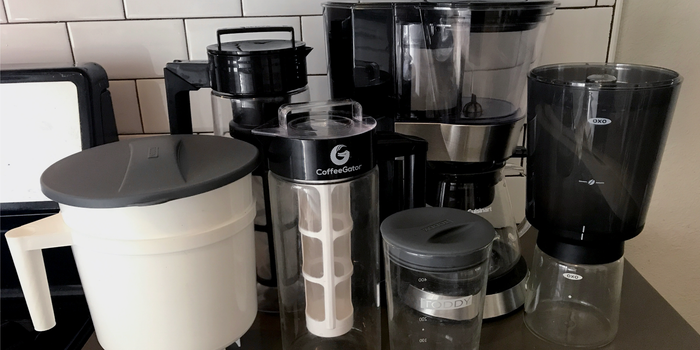 A bunch of cold-brew coffee makers in a row on a countertop as part of testing for our guide.
