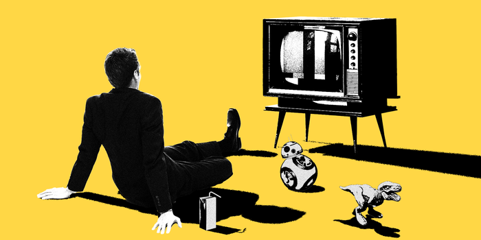 A business man sitting in front of a TV with other nostalgic items around him