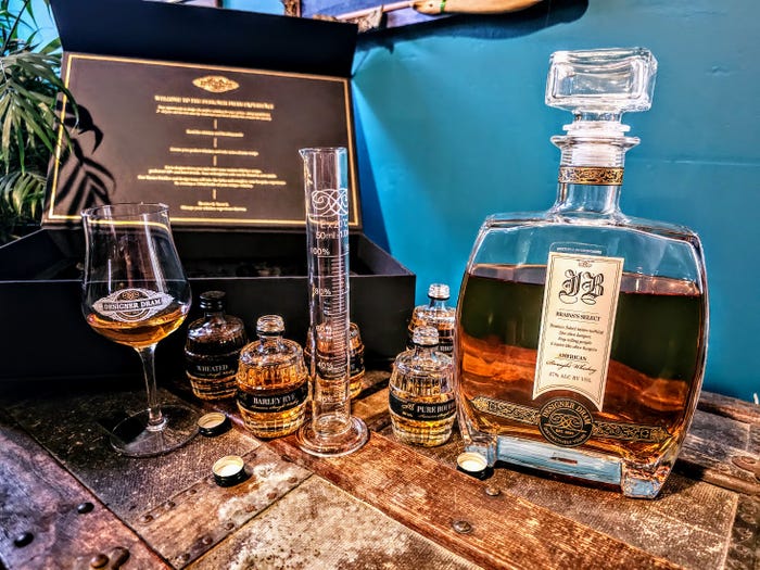 All the Designer Dram sampling items and the finished bottle are displayed on a wooden chest.