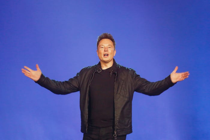 Elon Musk in front of a blue background.