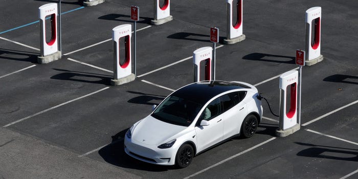 A Tesla car charging up at a Tesla Supercharger.