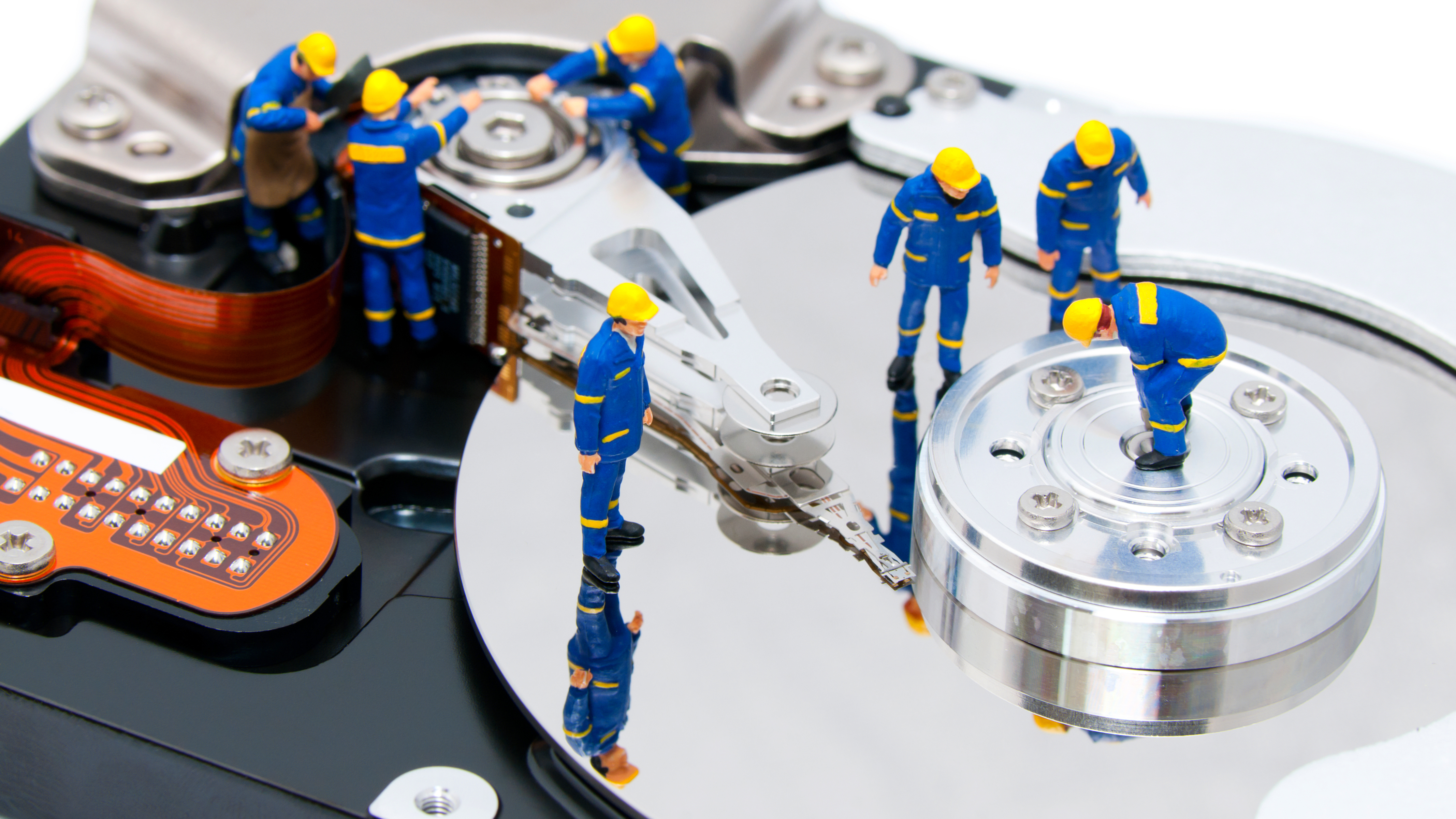 small figurines made to look like they are repairing a hard drive