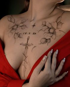 a woman with tattoos on her chest is holding onto a red dress and looking at the camera