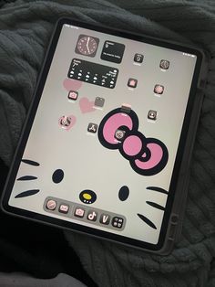 an ipad with a hello kitty sticker on the front and back cover sitting on a bed