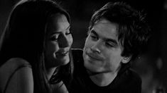 the young man and woman are looking at each other's eyes in black and white