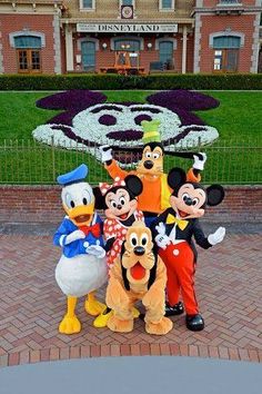 the mickey mouse family poses for a photo in front of disneyland's main street