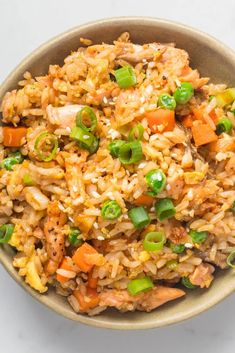 a bowl filled with rice and vegetables on top of a table