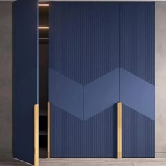 an open blue door with gold handles in front of a gray wall and concrete floor