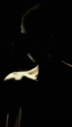a blurry image of a man with his hand on his chest and face in the dark
