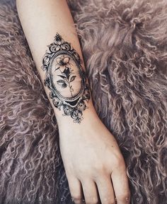 a woman's arm with a flower tattoo on it