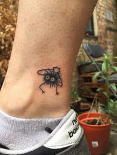 a small black and white tattoo on the ankle