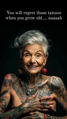 an older woman with tattoos on her chest and arms is smiling at the camera while she has