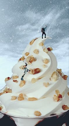 a cupcake with white frosting and small figurines on top in the snow