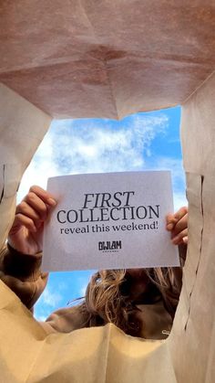 a woman holding up a sign that says first collection reveal this weekend on it's paper