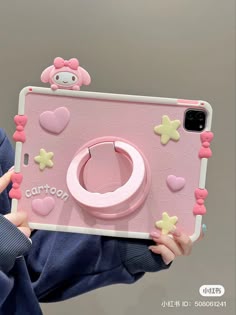 a person holding up a pink camera case