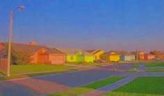 a row of houses on the side of a street with grass in front of them