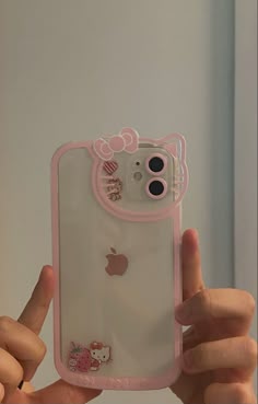 a person holding up an iphone case with hello kitty stickers on it