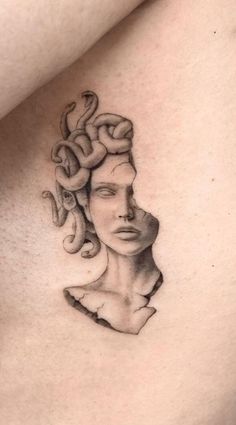 a woman's chest with a snake tattoo on her left side ribcage