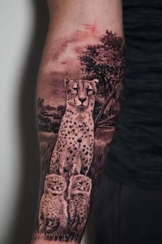 Cheetah tattoo with two cubs and wilderness prairie in the background.