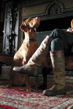 a woman sitting on a bench next to a brown dog wearing boots with the caption, brawngton saddlers