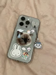 a phone case with an image of a cat and some stickers on the back