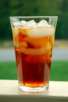 a tall glass filled with liquid sitting on top of a table
