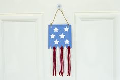 an american flag hanging on a door with red, white and blue tassels