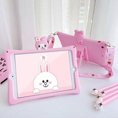 a pink tablet sitting on top of a white table