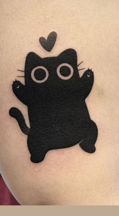 a black cat tattoo on the side of a woman's stomach with a heart above it