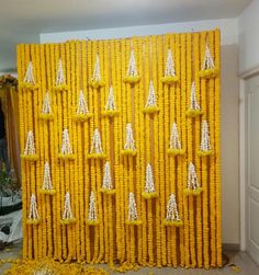 a wall made out of yellow flowers with white arrows on the front and back side