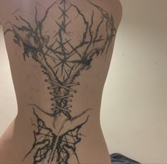 the back of a woman's body with barbed wire on her neck and shoulder