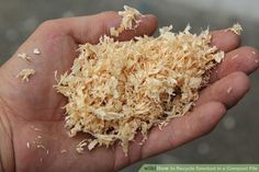 a person holding out their hand full of shredded wood shavings in the palm
