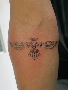 a close up of a person's leg with an eagle tattoo on the side