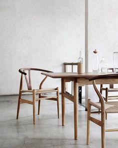 a wooden table with two chairs next to it and bottles on the table in front of it
