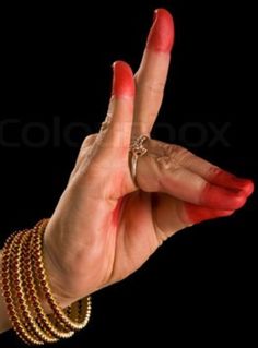 a woman's hand with red nail polish and bracelets holding up the peace sign