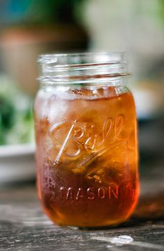a mason jar filled with liquid sitting on top of a wooden table